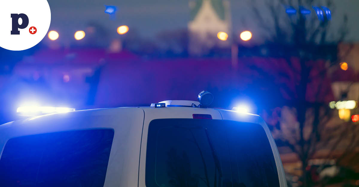 samochód policyjny z światłami na tle miasta