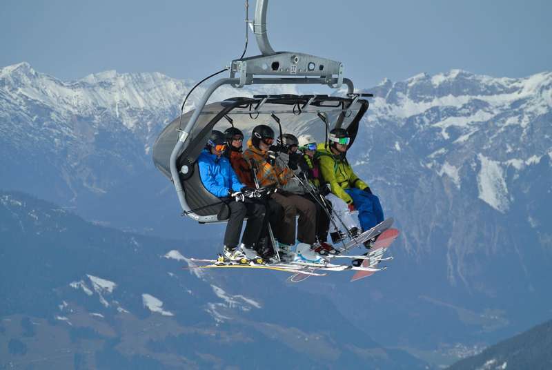 narciarze siedzący na wyciągu narciarskich