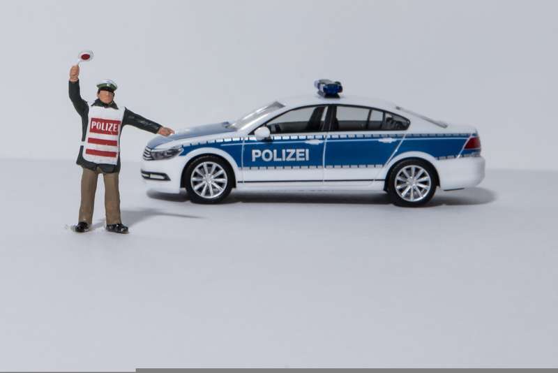 figurka policjanta i samochodu policyjnego nakazująca zatrzymanie się