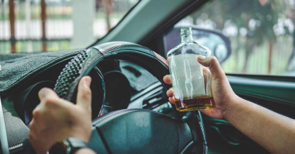 pijany kierowca, kierowca, alkohol za kółkiem, prowadzi po pijaku, wódka, butelka alkoholu, pusta butelka