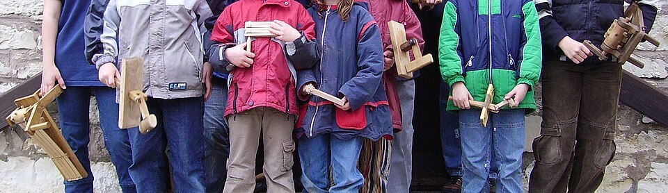 Dzieci z drewnianymi kołatkami (Ratschen) obchodzące miejscowość w Wielki Piątek w Austrii, zastępując dźwięk kościelnych dzwonów