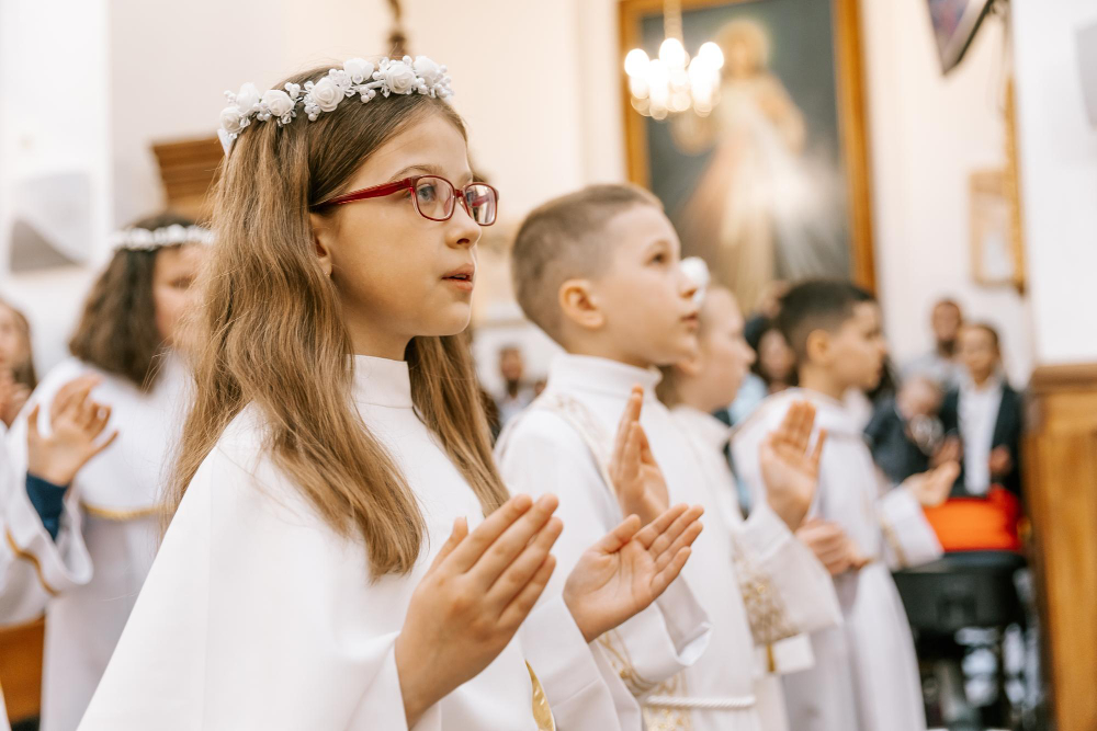 Dzieci podczas Pierwszej Komunii Świętej w Szwajcarii w trakcie uroczystej mszy w parafii katolickiej