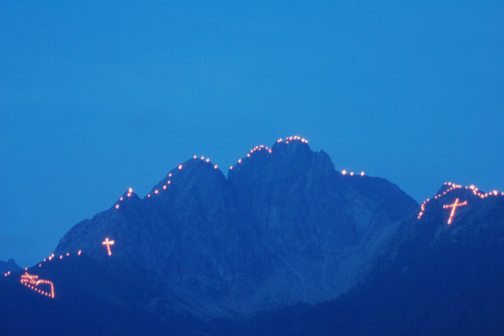 Bergfeuer w Alpach podczas Sonnwendfeier – płonący symbol na górskim zboczu