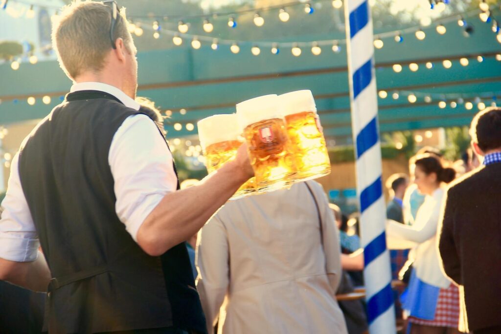 Piwo Maß niesione przez kelnera podczas Oktoberfestu w Monachium